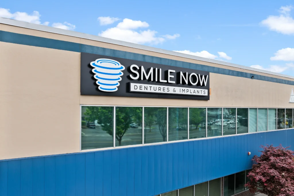 Exterior of office building with sign at Smile Now Tacoma Dentures and Implants