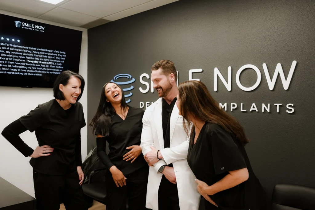 Friendly dental implant team laughing together at Smile Now Tacoma Dentures and Implants in Milton, WA