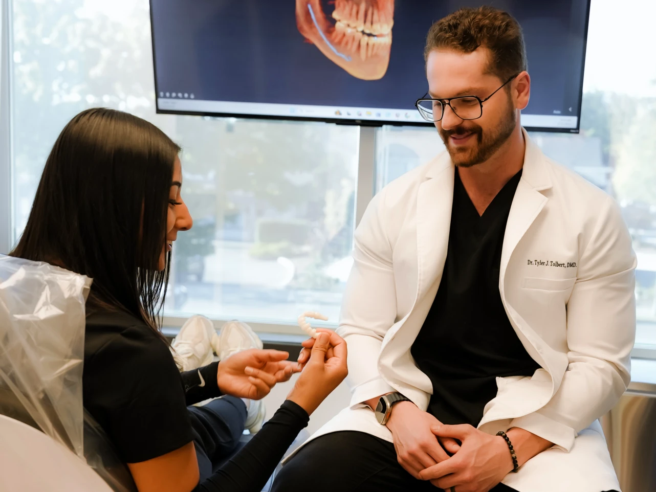 A patient reviewing high quality dental implants with their dentist to avoid bad dental implants.